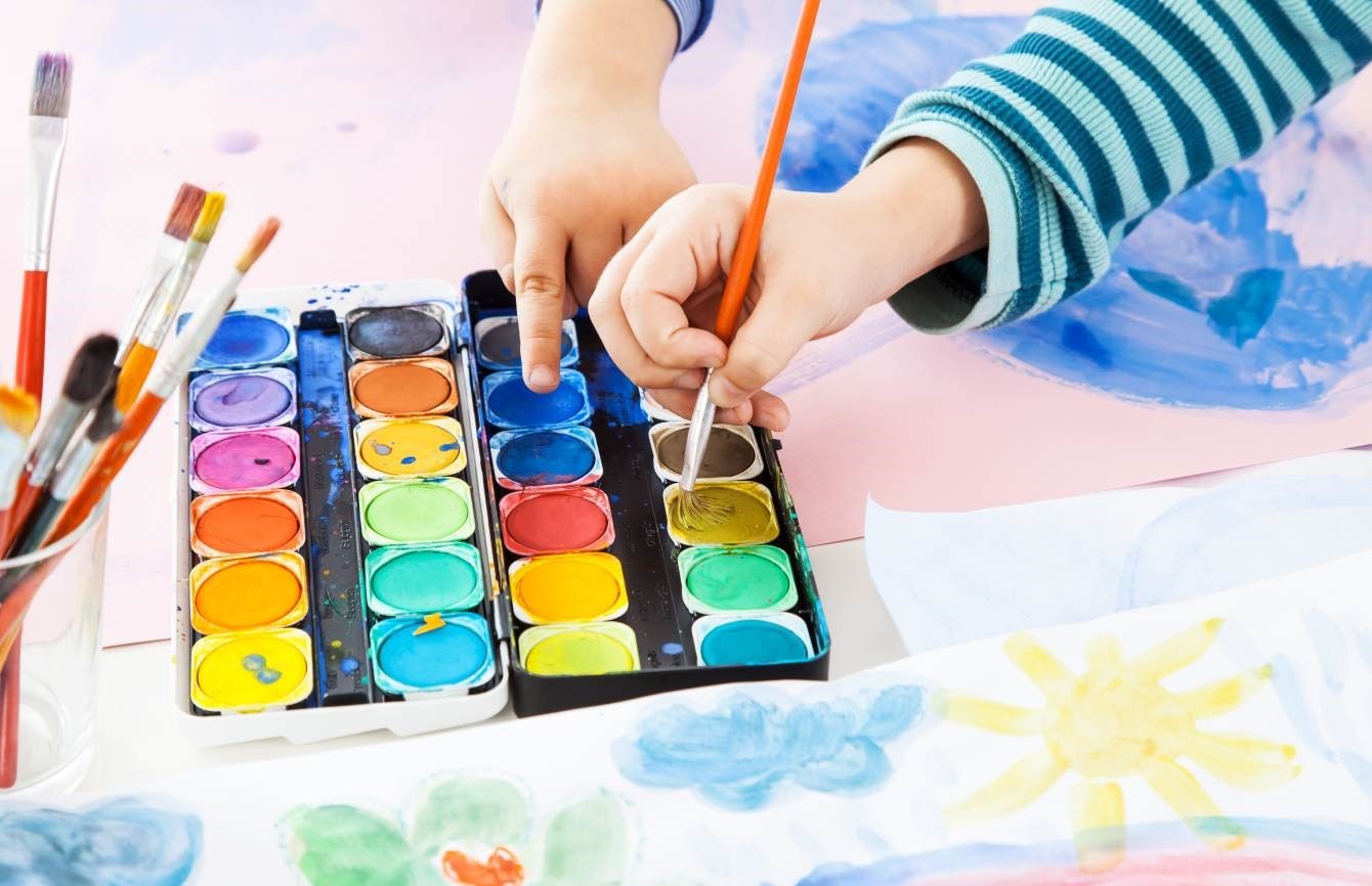 Picture of child's hand painting with watercolor