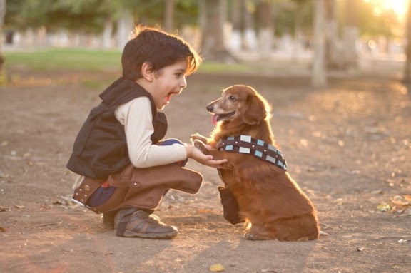Side view of a sitting happy boy with his pet dog.