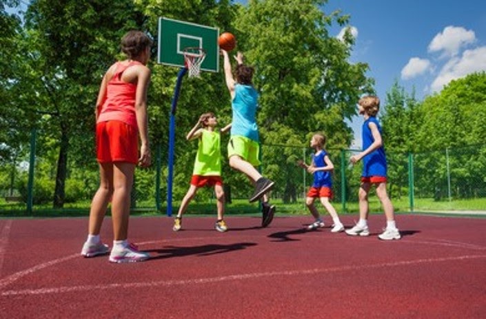 Five kids playing basketball in a basketball court