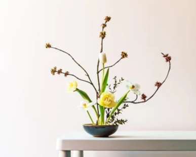 Image of Ikebana with yellow flowers and dried flowers.